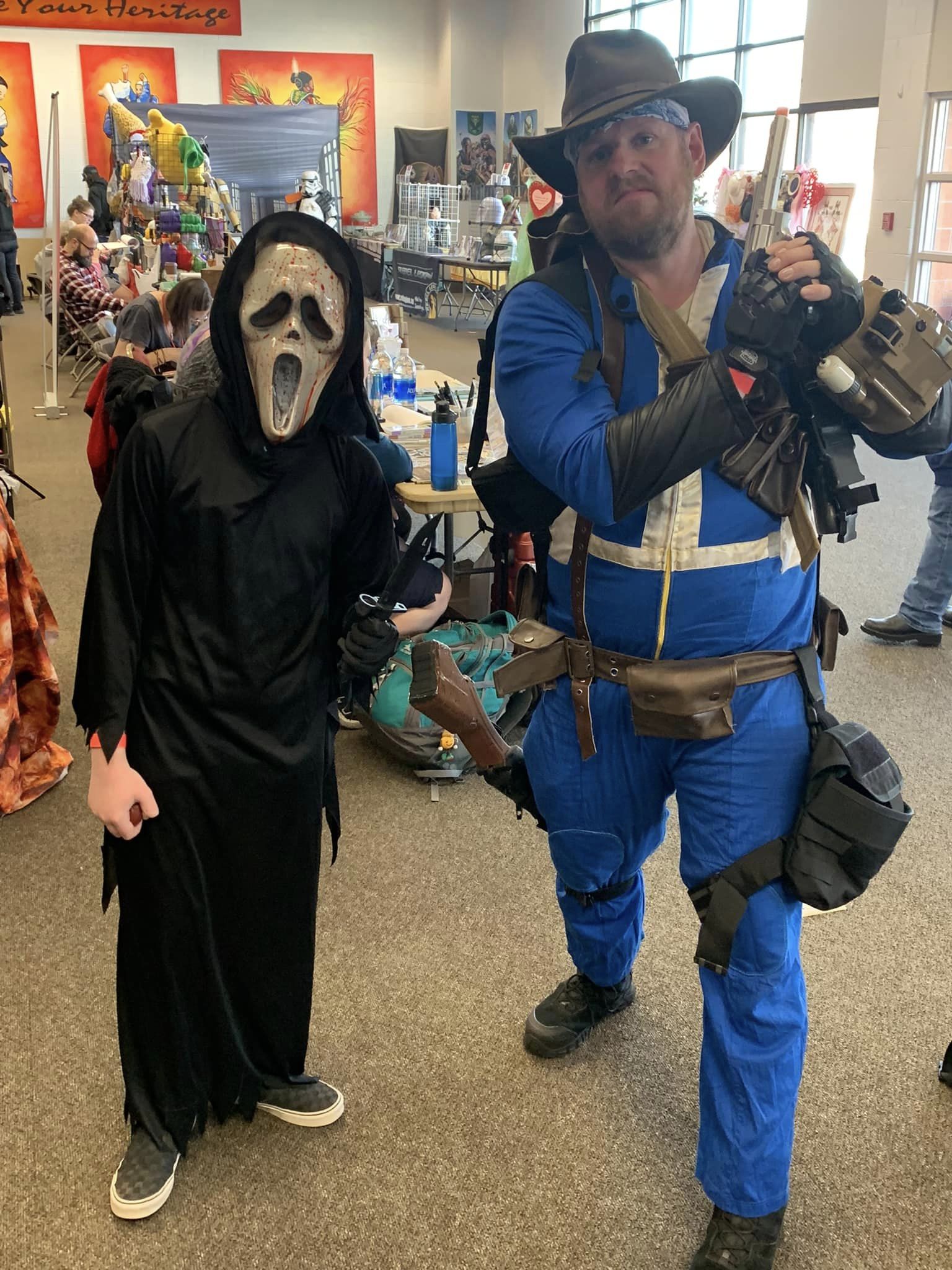 Costumed Batman attendee under a superhero-themed balloon arch at Border Town Comic Con