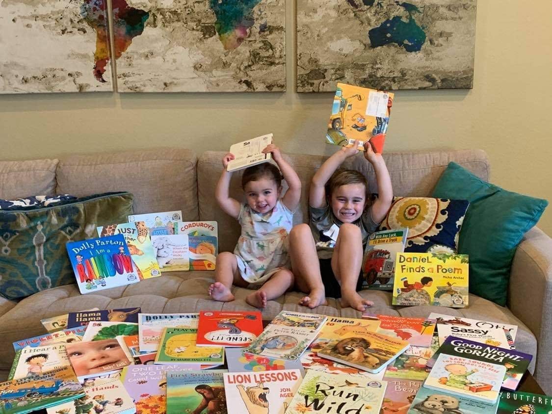 Two young children reading books together